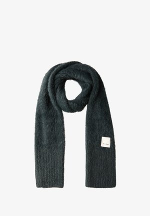 Écharpe vert foncé avec une texture douce et moelleuse. Présente un tricot côtelé à une extrémité et une petite étiquette avec la marque. Forme longue et rectangulaire.