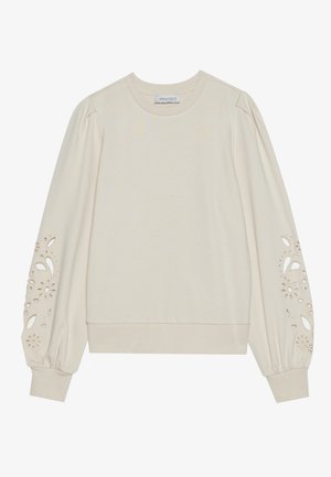 Vaalean beige huppari puffisilmuilla ja kukkaleikkaustavoilla hihojen suissa. Pehmeä kangas ja ribattua helmaa antamassa istuvuutta.