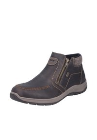 Bottine en cuir marron avec fermeture éclair latérale, coutures contrastées, semelle rembourrée et tige texturée. Col en tissu doux en accent.