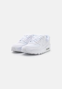 Baskets blanches Nike Air Max, en mesh et cuir, avec bout rond, semelle rembourrée, système de laçage et unité d'air visible.
