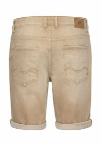 Shorts en denim beige avec une finition texturée, présentant deux poches arrière, des ourlets retroussés et un patch en cuir marron.