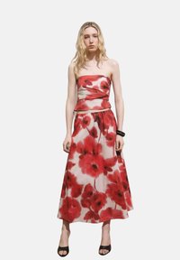 Trägerloses rotes Blumenkleid mit tailliertem Oberteil und fließendem Rock. Hergestellt aus leichtem Stoff, zeigt lebendige Mohnblumenmuster.