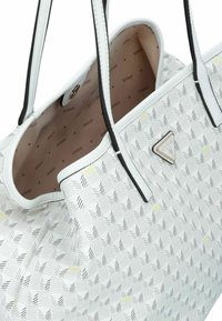 Borsa tote bianca con motivo geometrico, realizzata in materiale sintetico. Accenti neri e interno con stampa monogramma in beige chiaro. Dettaglio del logo a triangolo.