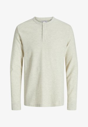 Pikkade varrukatega, heledast beigest henley särgist, millel on soonikuline tekstuur, ümar kaelus ja ees kolme nupuga lõhik.