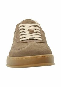 Baskets en daim marron avec des lacets beiges, un bout arrondi et une semelle en caoutchouc texturé. Présente des coutures discrètes et une étiquette avec le logo sur le côté.