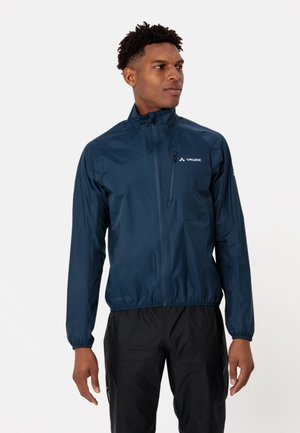 Giacca leggera blu navy realizzata in materiale resistente all'acqua. Presenta un alto colletto, chiusura a zip completa, polsi elastici e una piccola tasca frontale.