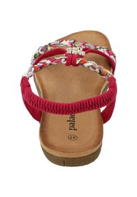 Röd sandal med flätade textilremmar, blommiga detaljer, en slät, formad fotbädd och en texturerad gummisula.