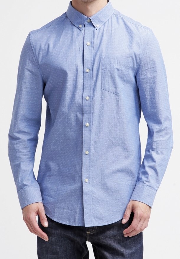 Vaaleansininen nappipaita, jossa on kaulus, pieni rintatasku ja hienovarainen pistekuvio, valmistettu kudotusta kankaasta.