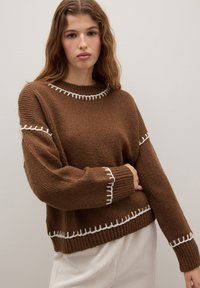 Brauner gestrickter Pullover mit weißen kontrastierenden Nähten entlang des Halsausschnitts und der Ärmel, mit lässiger Passform und gerippten Bündchen.