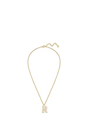 Collana con catena d'oro con un ciondolo a forma della lettera "R" con un design a strisce, distesa su uno sfondo bianco.