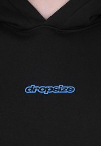Black hoodie with a blue "dropsize" logo centered on the chest, worn by a person with visible neck and upper chest skin.