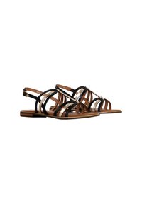 Platbruine sandalen met zwarte en metallic gouden kruisschoenenbanden en verstelbare enkelgespen op een witte achtergrond.