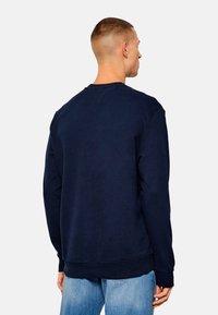 Sweatshirt in cotone blu navy con maniche lunghe, polsini e orlo a costine, caratterizzato da un colletto rotondo e una texture liscia. La vista posteriore mostra le cuciture delle spalle e un design semplice.