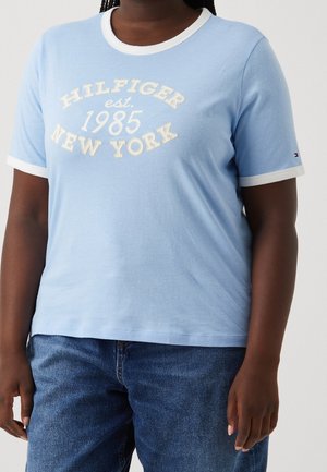 Lys blå bomulds T-shirt med hvid kontrastkrave og ærmer. Har et grafik med "HILFIGER est. 1985 NEW YORK" i lys creme.