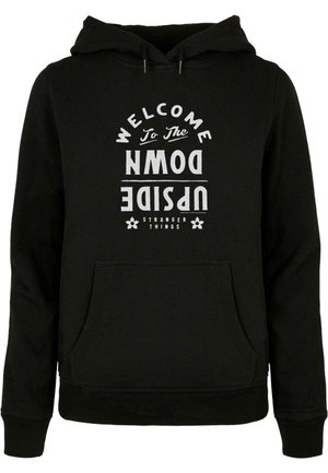 Hanorac negru cu buzunar frontal, glugă cu șnur și imprimeu grafic alb care spune "BINE AI VENIT ÎN LATERALUL INVERS".