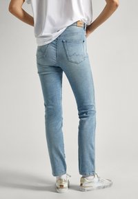 Heled sinised kitsas prooviga teksad, peened õmblemise detailid ja kaks tagataskut. Kantud valgetest tennistest, millel on kuldsed aktsendid.