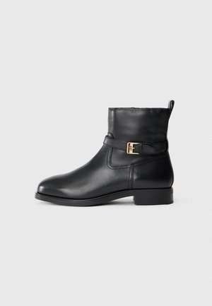 Bottines en cuir noir avec un bout arrondi, une sangle latérale et un détail de boucle dorée, un petit talon carré et une texture lisse.