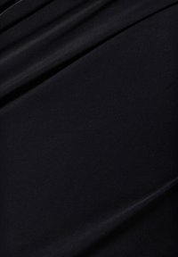 Sort stof med en glat tekstur, der har draperede folder og en subtil overfladeskin, som viser en fin, ensartet vævning.