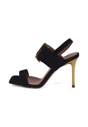 Sandale en daim noir à talon haut avec bout ouvert, large bride et grande boucle dorée, et talon stiletto fin métallique doré.