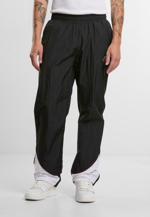 Zwarte lichte broek met een elastische tailleband, met een gestructureerd oppervlak, rode accenten langs de zoom en zijzakken.