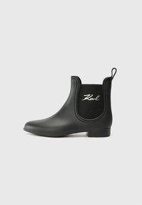 Black rubber ankle boot with a smooth finish, elastic side panels, and a pull tab at the back. Features subtle white logo detail on the side.