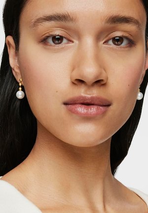 Gold dangle earrings with a single white pearl at the bottom. The earrings feature a smooth texture and round shape.