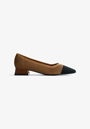 Zapato de tacón de tela texturizada marrón con punta afilada y capuchón de ante negro. Presenta un tacón bajo y angular marrón con base negra.