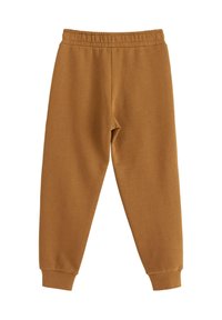 Braune Sweatpants aus weichem Stoff, mit einem elastischen Bund, schmal zulaufenden Knöcheln und einer glatten Textur. Keine sichtbaren Muster oder Akzente.