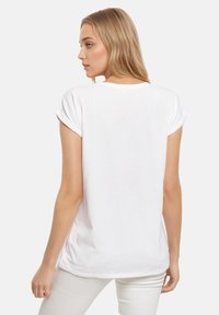 White short-sleeve t-shirt with rolled cuffs, round neckline, smooth fabric, and relaxed fit. Back view shows simplicity in design.
