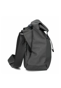 Bolsa de tela gris con una forma estructurada, que presenta un cierre enrollable, superficie texturizada con un diseño geométrico y correa ajustable.