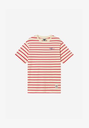 Κρεμ κοντομάνικη μπλούζα με κόκκινες οριζόντιες ρίγες, μικρό μπλε καλλιγραφικό κείμενο στο στήθος και ορθογώνιο αυτοκόλλητο κοντά στο κάτω τελείωμα.