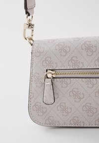 Borsa a tracolla compatta in tessuto grigio chiaro con motivo a logo in rilievo, zip dorata e hardware a clip. Forma rettangolare con superficie testurizzata.