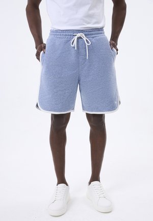 Shorts de sport bleu clair avec une taille à cordon, poches latérales et bord blanc le long de l'ourlet. Fabrication en tissu doux et texturé.