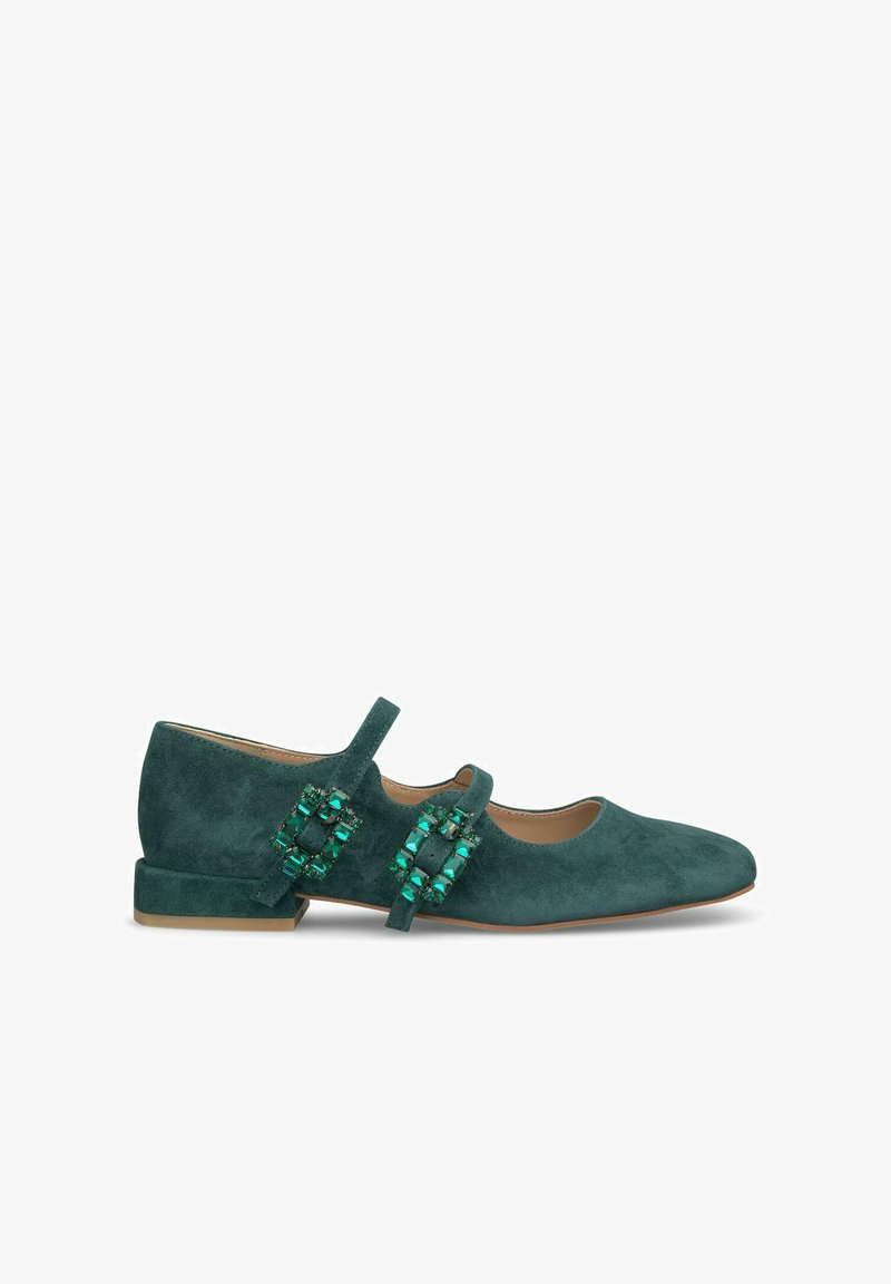 Zapato plano de ante en color verde azulado con punta redondeada y tacón bajo. Presenta una hebilla decorativa con gemas verdes en el lateral y una correa ajustable.