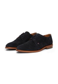 Donkerblauwe suède schoenen met een ronde neus, voorzien van een vetersluiting, bijpassende stiksels en een bruine houten zool.