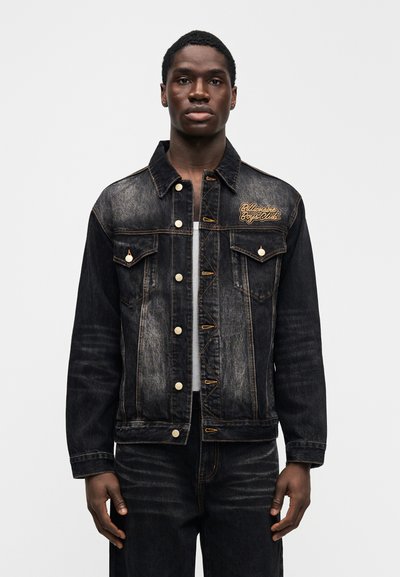 Μαύρο τζιν μπουφάν με ελαφριά ξεθώριασμα, χρυστά ράμματα και ανάγλυφο λογότυπο στο στήθος. Διαθέτει κλασικό κούμπωμα με κουμπιά και τσέπες στο στήθος.