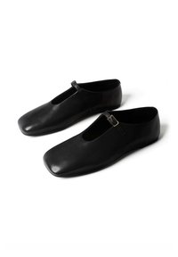 Mustadest nahast madalad kingad ruudukujuliste varbavahedega ja ühe õhukese rihmaga, millel väike pandlaga klamber peal.