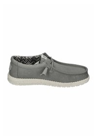 Graue Stoff-Schlupfschuhe mit strukturierter Oberseite, elastischem Detail und einer weiß gesprenkelten Gummisohle. Das Innere zeigt ein schwarz-weißes Fischgrätmuster.
