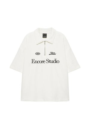 Polo blanc à manches courtes avec col zippé et texte noir "Encore Studio," "Urban movement," et "P&B" sur le devant.