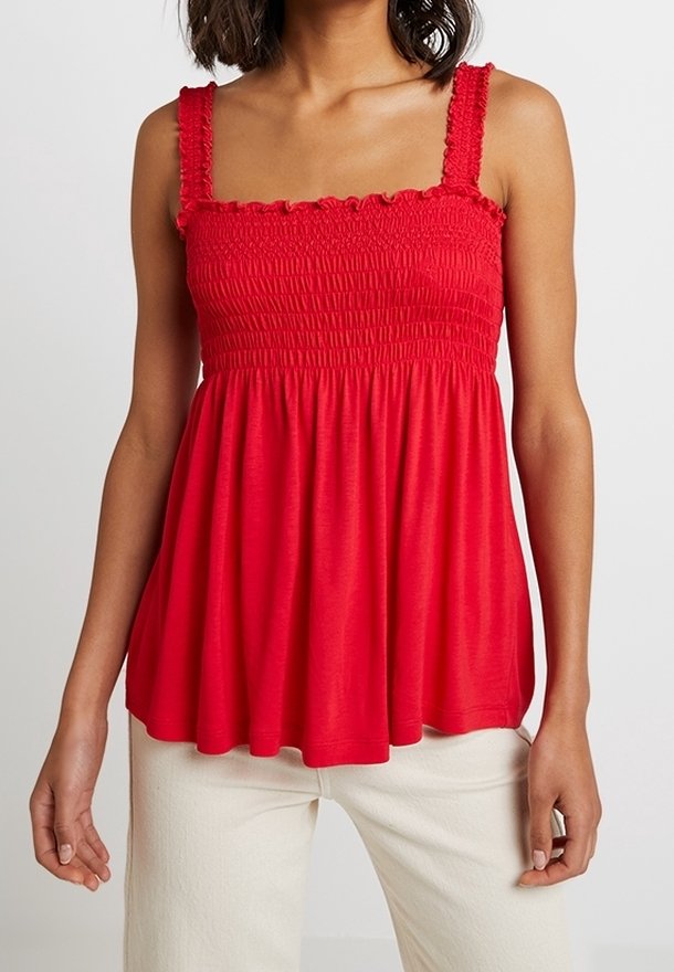 Röd, lätt topp med fyrkantig halsringning och smockad byst, med volangaxlar och en utsvängd silhuett. Mjuk tygtstruktur.