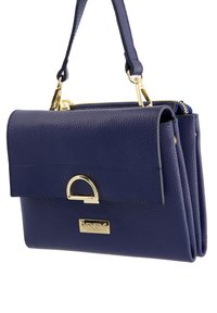 Navy blue leather handbag with a textured finish, gold hardware accents, fold-over flap, and a zip closure. Features a detachable strap.