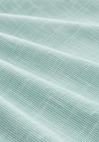 Light teal fabric with a textured, grid pattern. The material has a soft appearance with visible folds and creases.