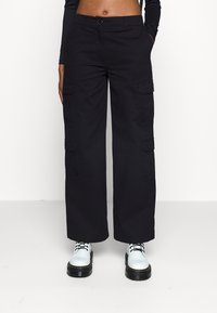 Pantalons cargo noirs à jambes larges, en tissu de coton. Comprend des poches latérales et une fermeture à bouton à la taille.
