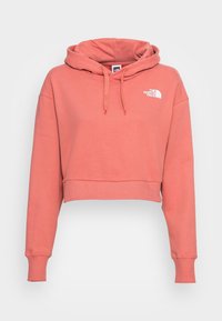 Korte hoodie in koraalkleur, gemaakt van zachte stof. Voorzien van een capuchon met trekkoord, lange mouwen en een wit logo op de borst.