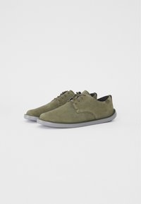 Scarpe in suede verde oliva con una texture liscia, punta tonda e design low-top. Presentano suola in gomma grigia e chiusura con lacci semplice.