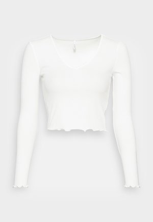 Biely dlhý rukáv cropped top s výstrihom do V, vyrobený z rebrovanej látky, so zvlnenými okrajmi a priliehavým strihom.