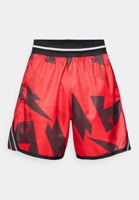 Rote sportliche Shorts mit einem schwarzen abstrakten Muster, elastischem Bund mit weißen und schwarzen Streifen, hergestellt aus leichtem, glänzendem Material.