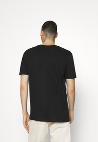 Černé tričko s krátkým sleeves a klasickým kulatým výstřihem, vyrobené z měkké bavlny. Má jednoduchý design a standardní střih.