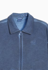 Giacca in pile blu con colletto piatto, cerniera full zip e logo ricamato sul petto. Texture morbida e finitura in tessuto liscia.