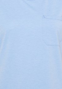 Ljusblå kortärmad t-shirt gjord av mjuk bomull. Har ett litet ficka på vänster bröst med rektangulär form. Enkel design.